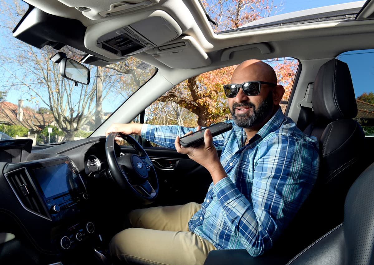 Man in a car dictating to iPhone